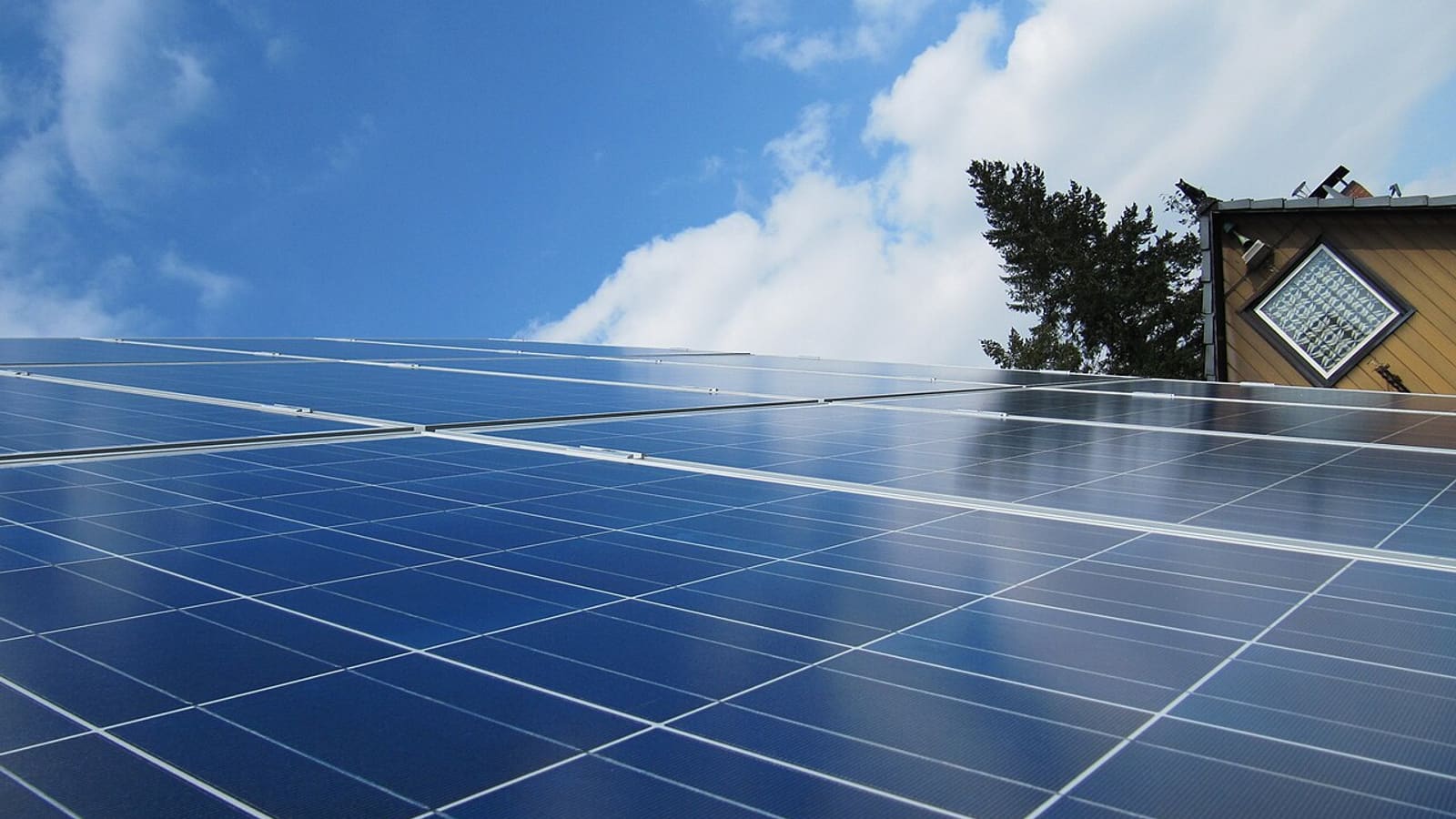 Photovoltaik-Module auf einem Hausdach vor blauem Himmel